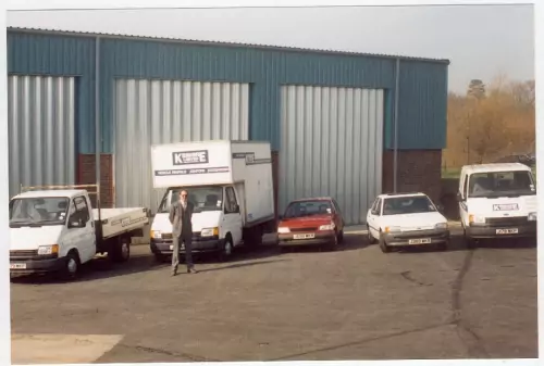 Photo: Paul Kennedy and some of the hire fleet in front of the newly-completed workshop building.